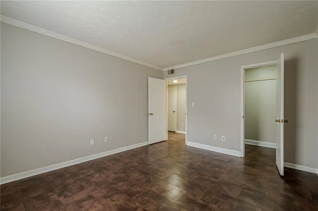 Unfurnished bedroom featuring a textured ceiling and ornamental molding