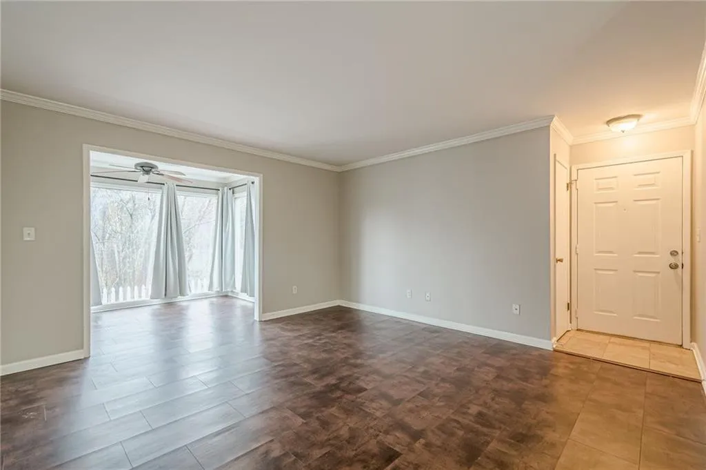 Empty room featuring ornamental molding and baseboards