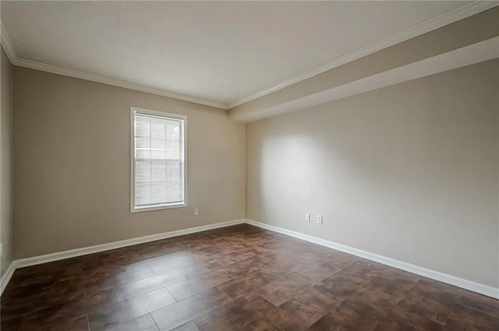 Empty room featuring crown molding and baseboards