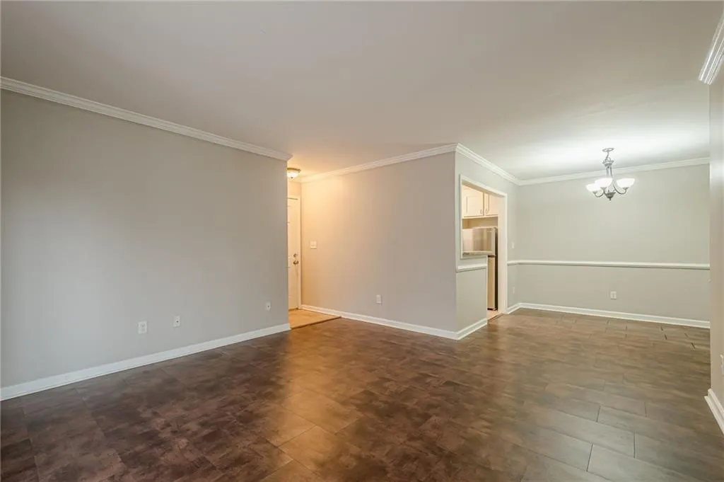 Unfurnished room with a chandelier and ornamental molding