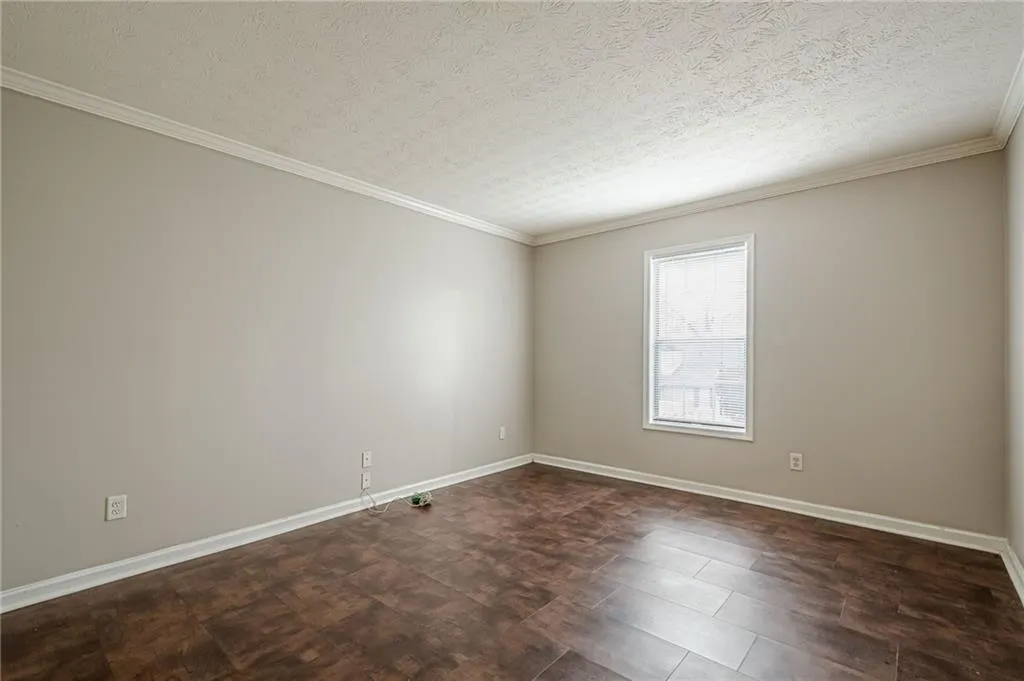 Spare room featuring a textured ceiling and crown molding