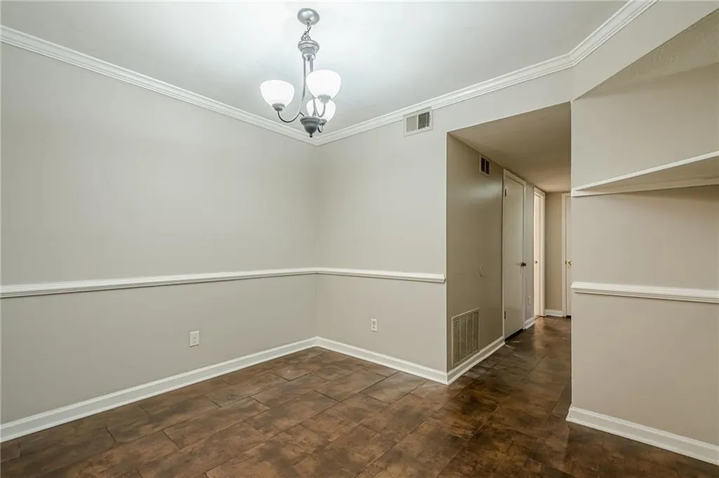Unfurnished room with crown molding and a chandelier