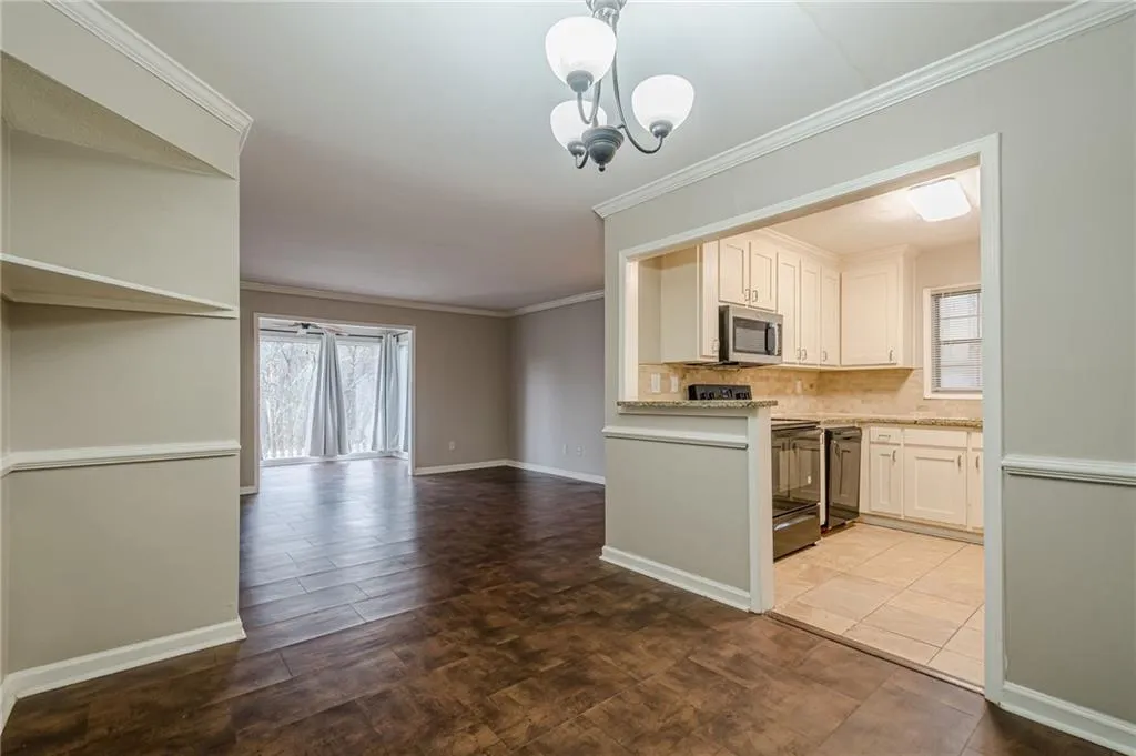 Kitchen with crown molding, black appliances, tasteful backsplash, a chandelier, and open floor plan