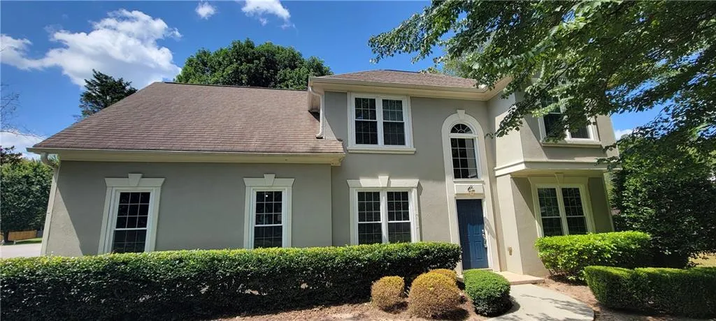 Stucco exterior with multiple window styles, including arched and rectangular designs