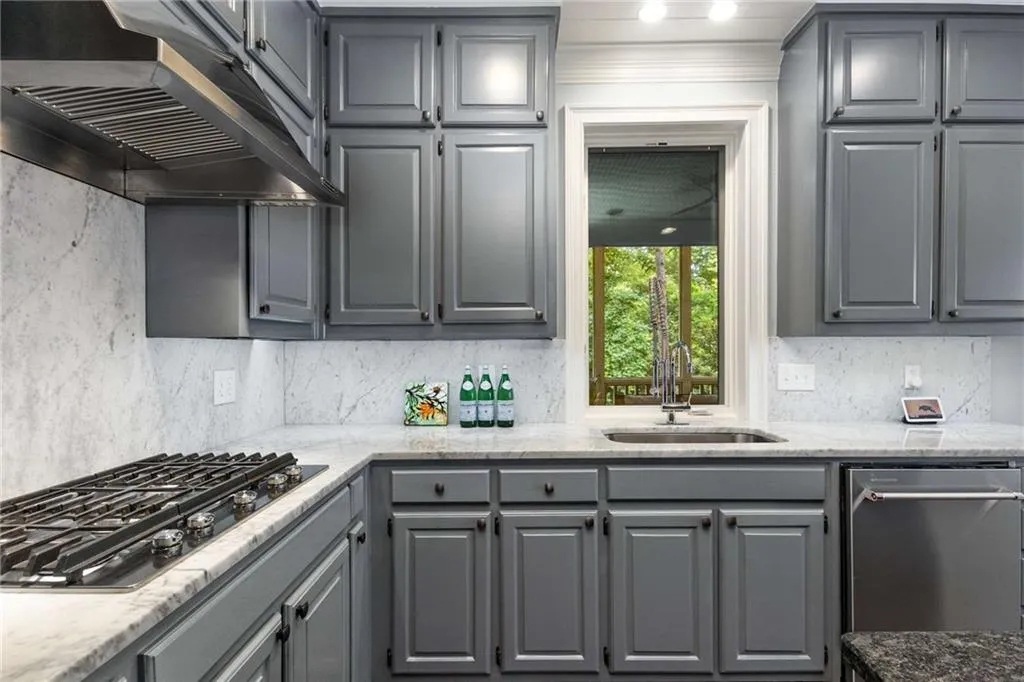 The kitchen features wood cabinetry all the way to the ceiling