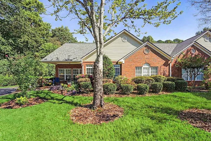 Brick exterior with siding accents, gabled roof, and circular window details