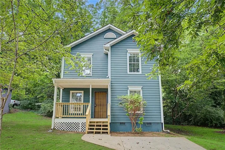 Two-story residence featuring blue siding, white trim, and a covered front porch