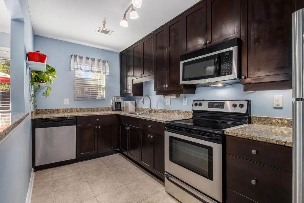 Kitchen with Sleek Dark Cabinetry, Stainless Steel Appliances, and Granite Countertops