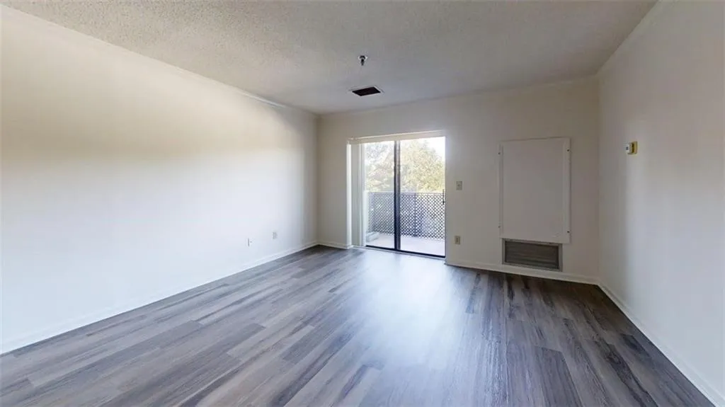 Unfurnished room with dark wood-type flooring, a textured ceiling, and crown molding