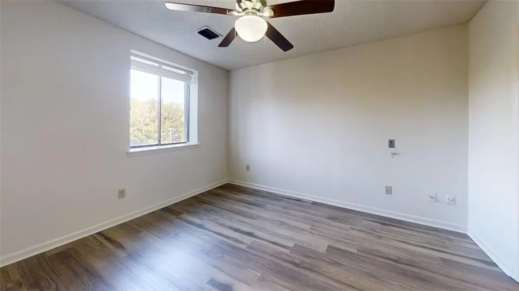 Unfurnished room with wood finished floors, a textured ceiling, and ceiling fan