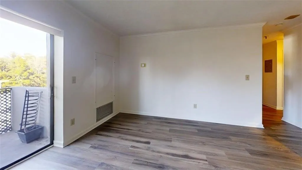 Spare room with ornamental molding and dark wood-style flooring