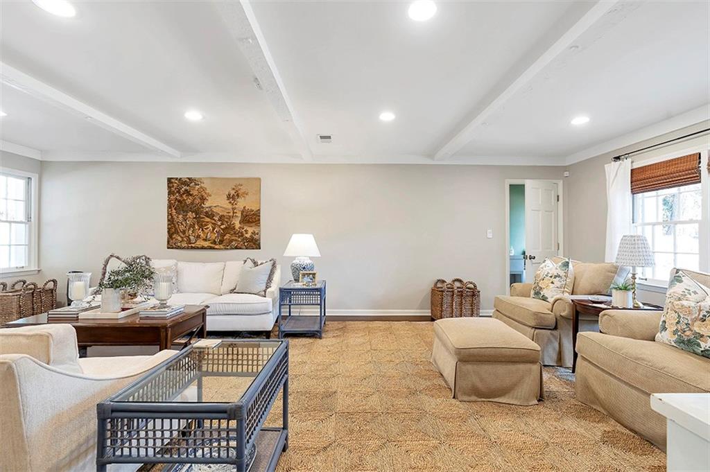 Living room with light colored carpet and beam ceiling