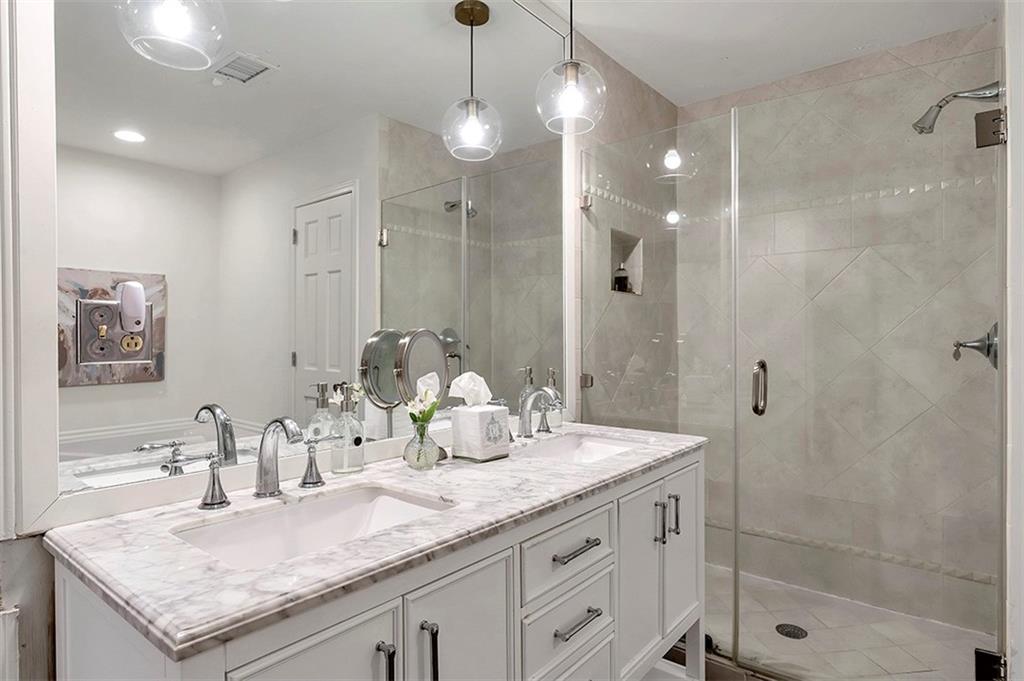 Bathroom featuring walk in shower, double sink, and oversized vanity