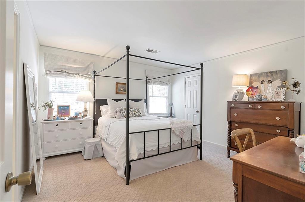 Carpeted bedroom with multiple windows and a notable chandelier