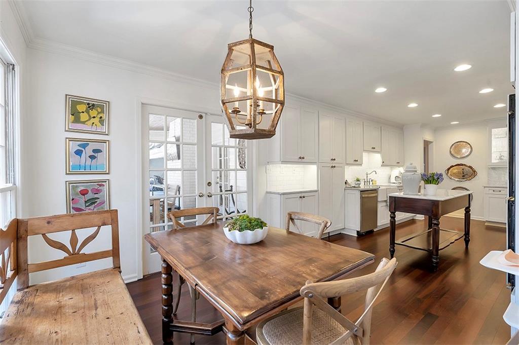 Dining room featuring ornamental molding, dark hardwood / wood-style flooring, sink, a notable chandelier, and french doors