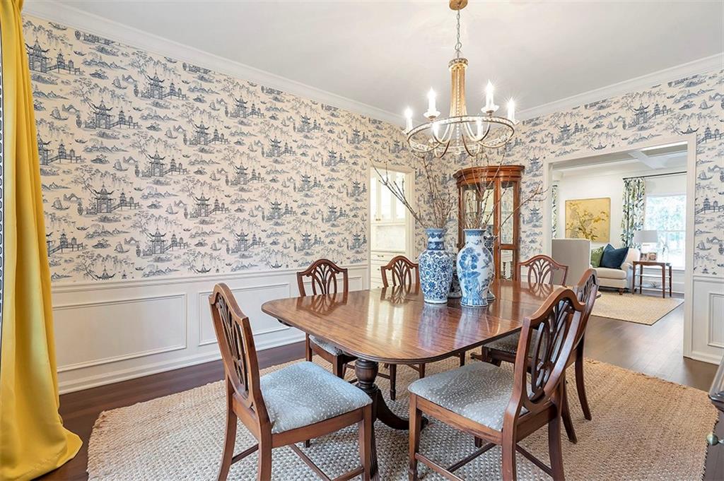 Dining area featuring dark hardwood / wood-style floors, a notable chandelier, and crown molding