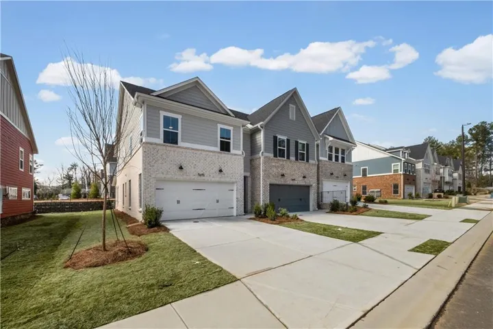 Traditional-style house with brick siding, an attached garage, and driveway