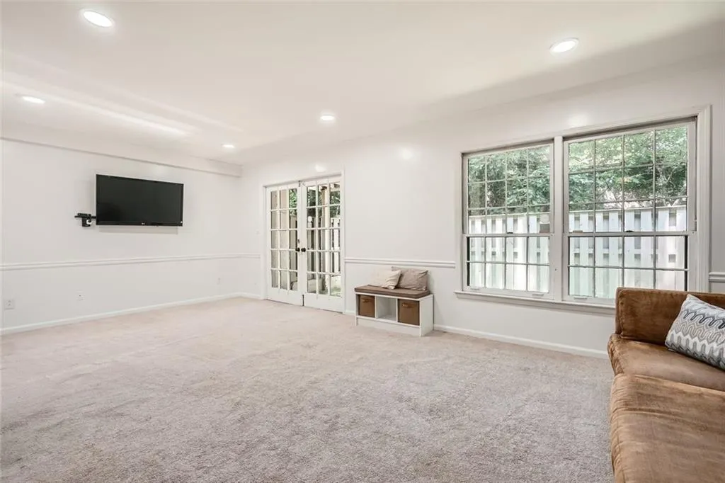 Carpeted living area featuring plenty of natural light, french doors, and recessed lighting