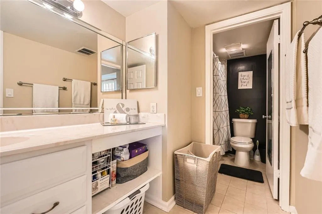 Bathroom featuring light tile patterned floors, curtained shower, and vanity