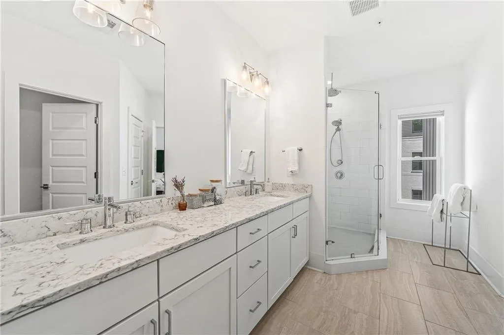 Full bath with double vanity and a stall shower