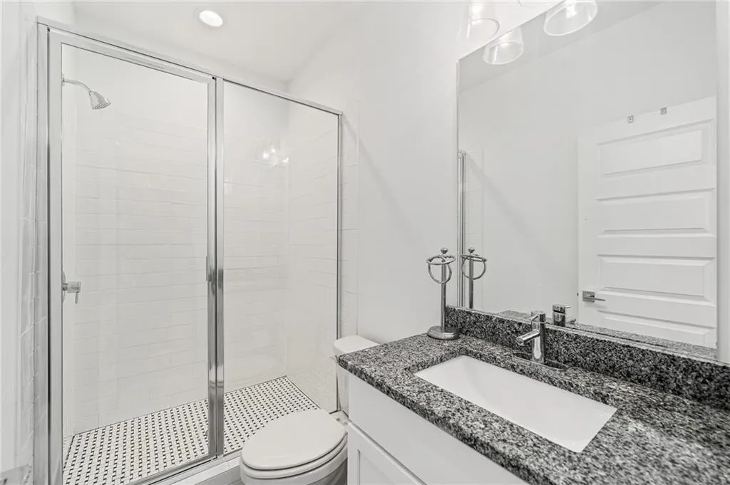 Bathroom featuring a stall shower, vanity, and recessed lighting