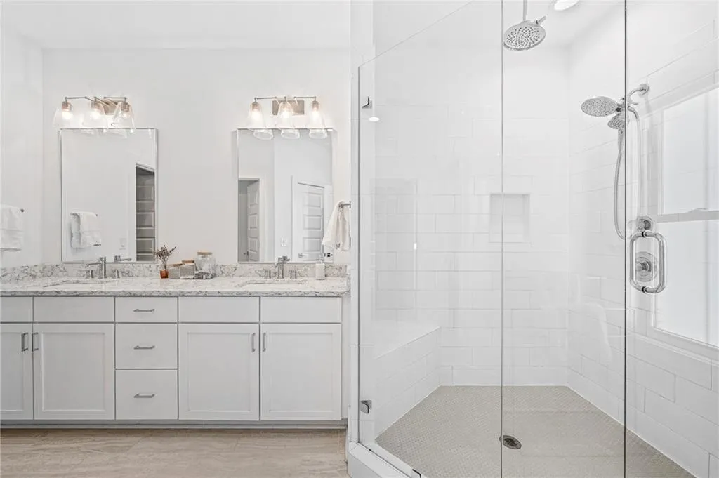 Full bath with a stall shower and double vanity