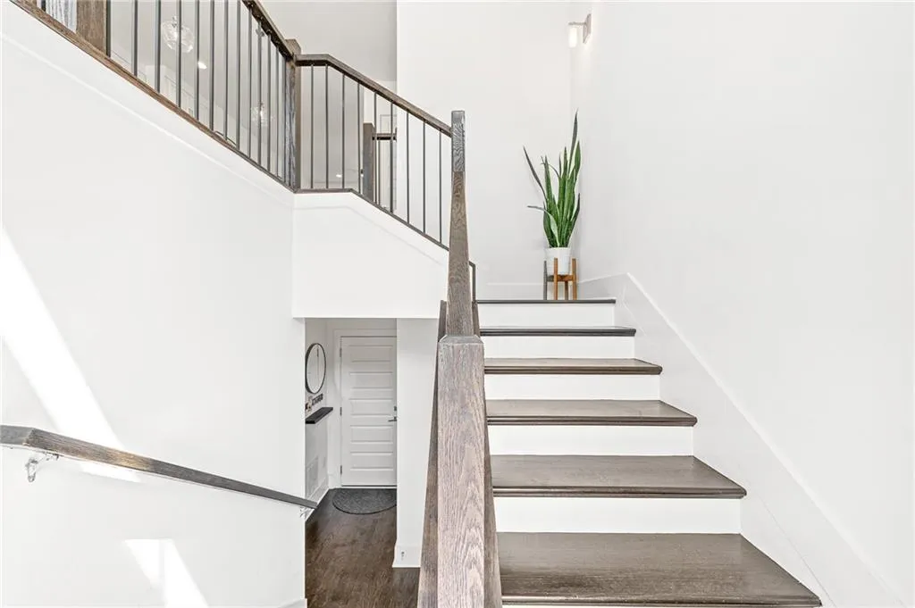 Staircase featuring wood finished floors and a towering ceiling