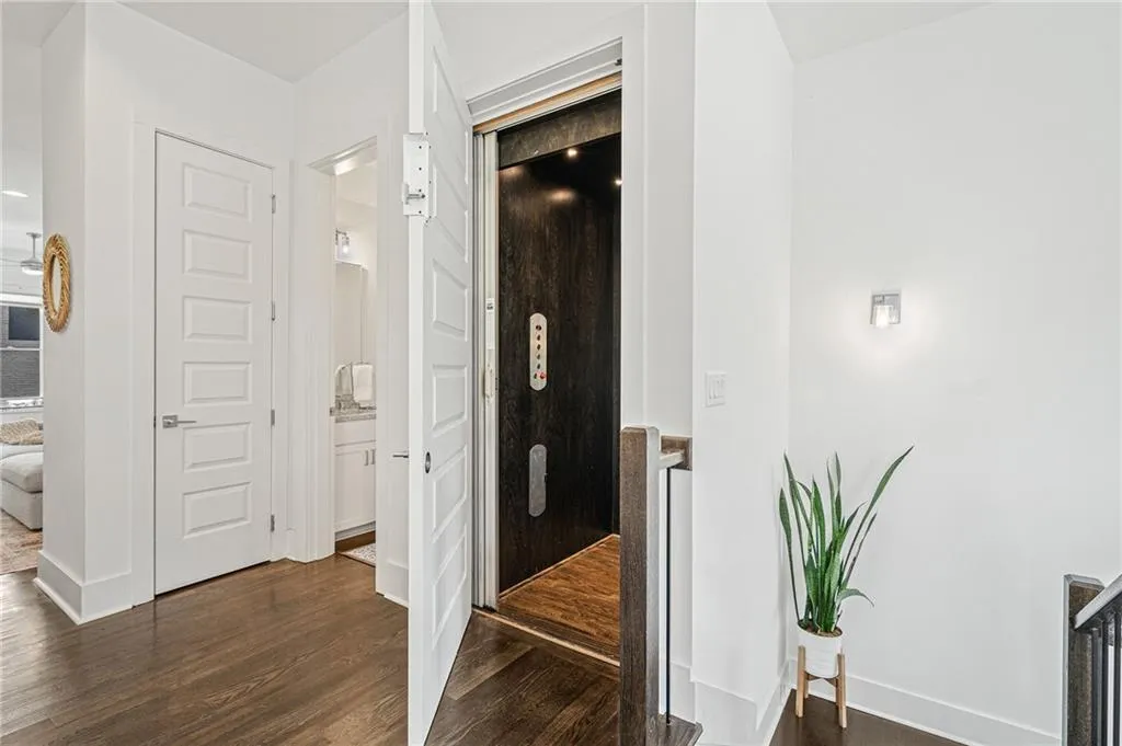 Corridor with dark wood-type flooring and elevator