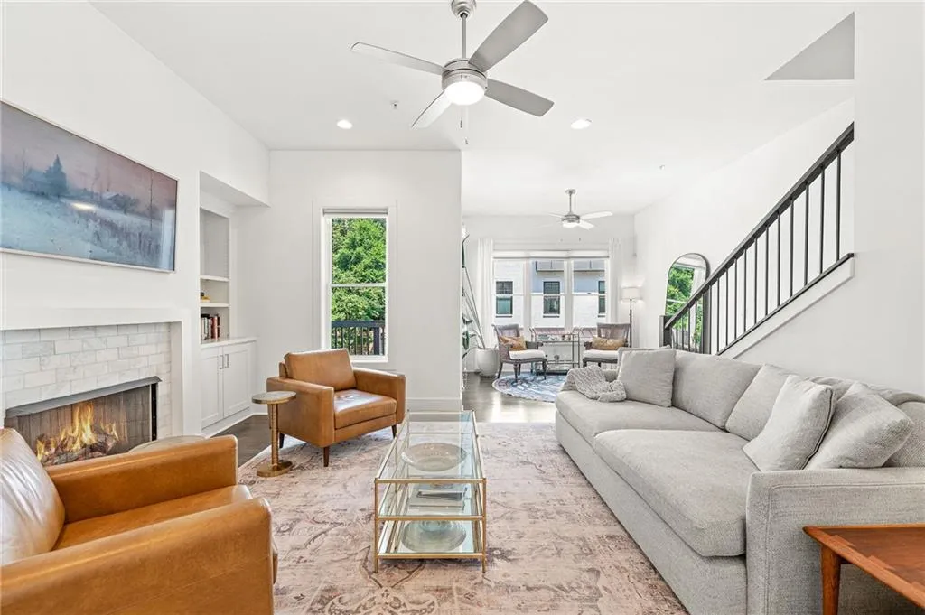 Living room with built in features, recessed lighting, wood finished floors, a fireplace, and stairway