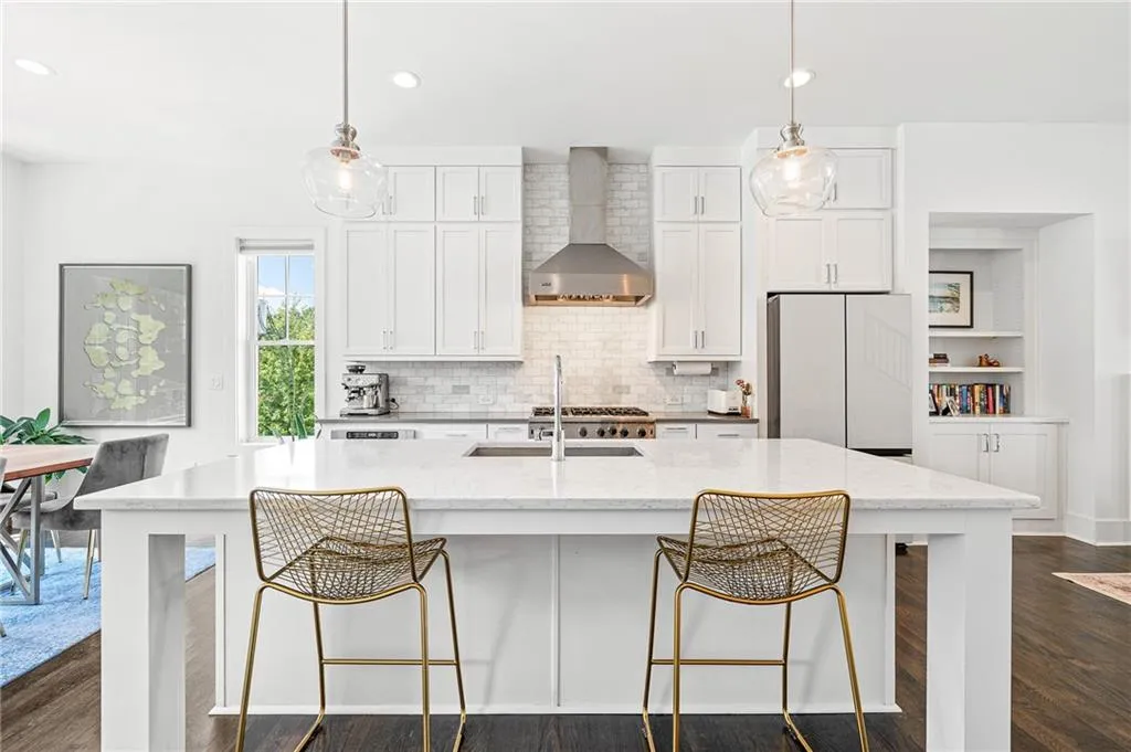 Kitchen with recessed lighting, dark wood-type flooring, white cabinetry, a spacious island, and wall chimney exhaust hood