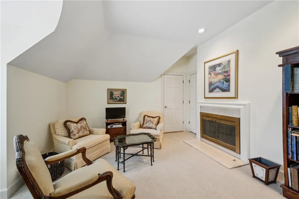 Upstairs play room or sitting area with fireplace and access to attic