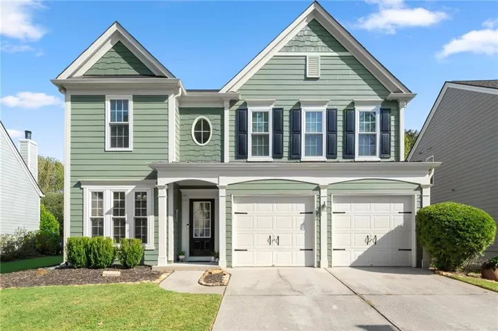 Two-story residence featuring green siding and white trim
