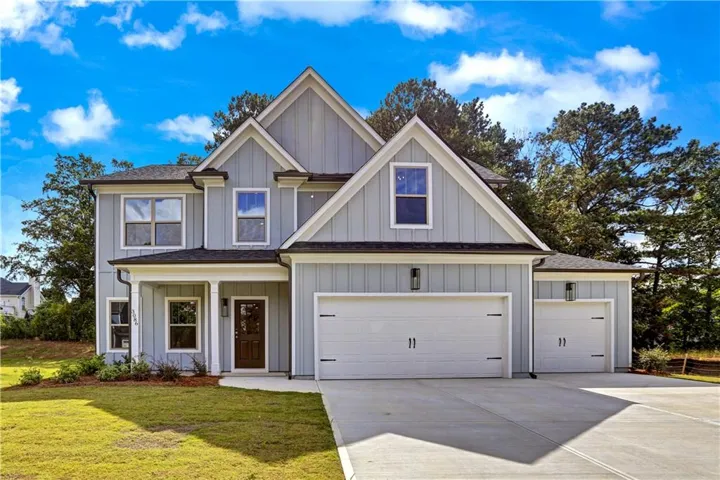 View of front of house featuring covered porch, driveway, a front lawn, and board and batten siding