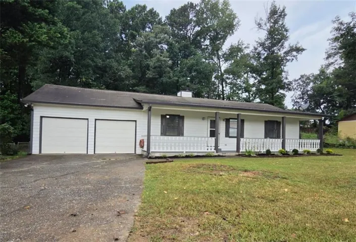 Ranch-style exterior with white siding, covered front porch, and a two-car garage