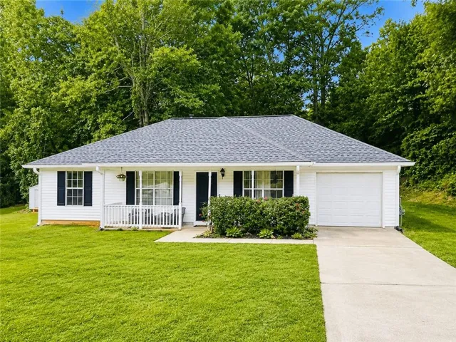 Single-story residence featuring white siding and a gray shingle roof