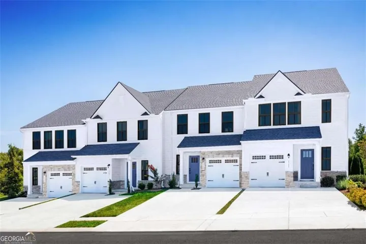 Contemporary townhome exteriors featuring white siding, dark trim windows, and gray shingle roofs