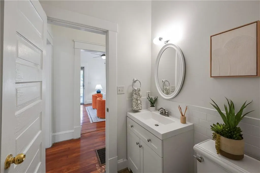 Half bath featuring vanity, dark wood-type flooring, and ceiling fan