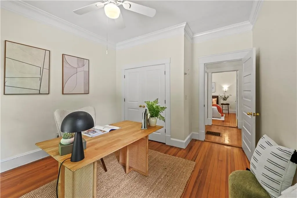 Office with wood-type flooring, crown molding, an AC wall unit, and ceiling fan