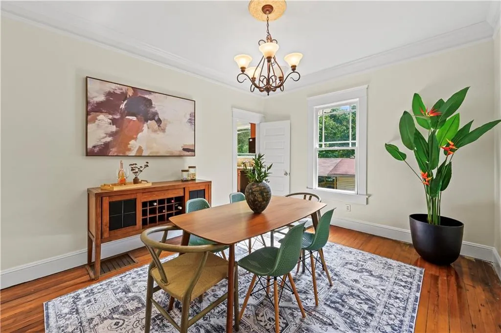 Dining room with crown molding, wood-type flooring, and a chandelier