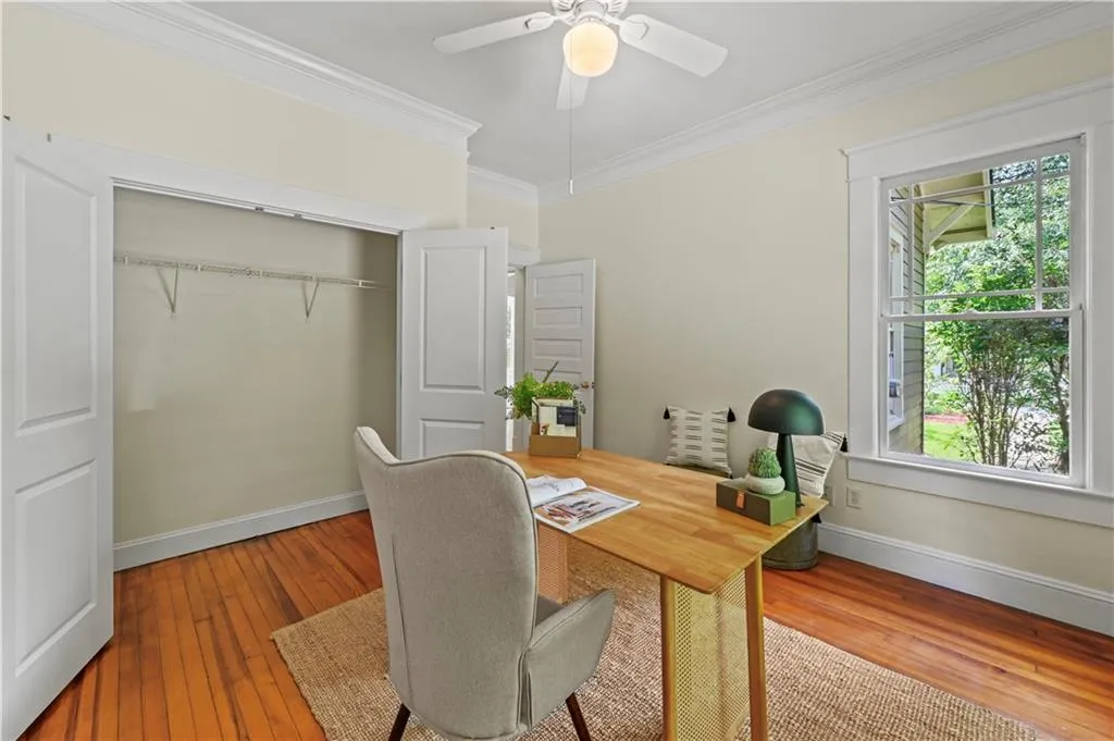 Home office with crown molding, hardwood / wood-style flooring, and ceiling fan