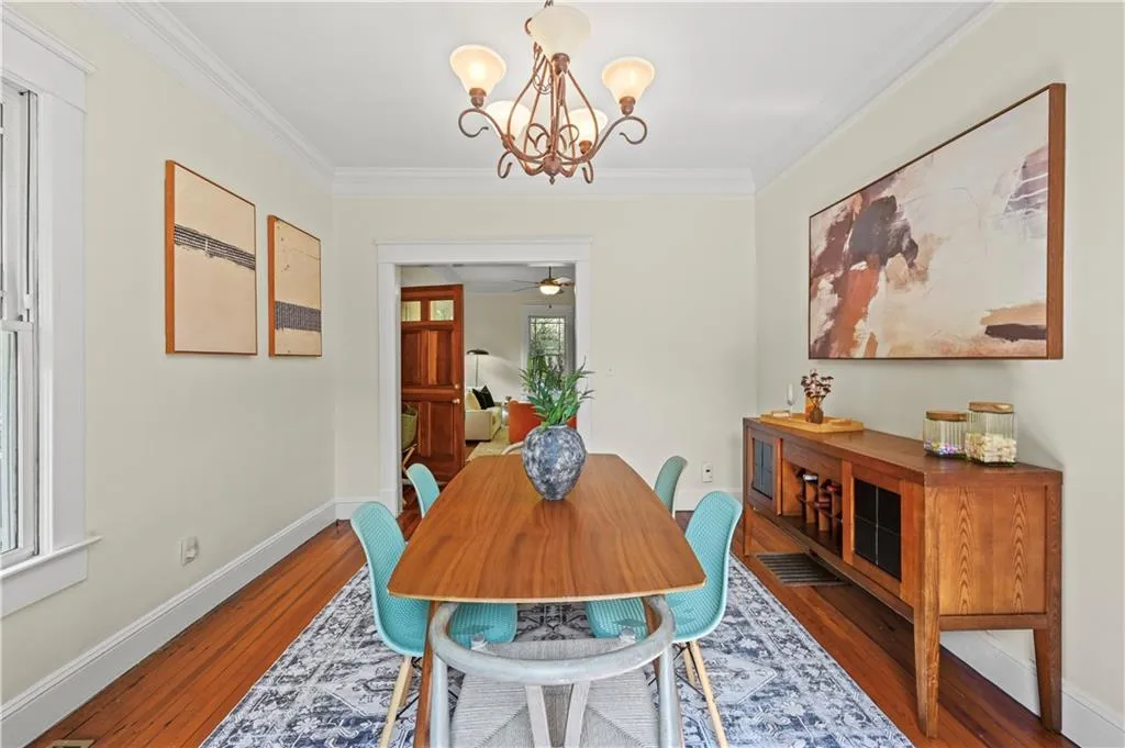 Dining room featuring ornamental molding, a chandelier, wood finished floors, and a ceiling fan