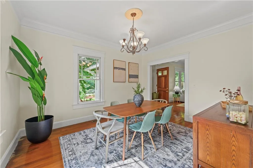 Dining room featuring ornamental molding, wood finished floors, healthy amount of natural light, and a chandelier