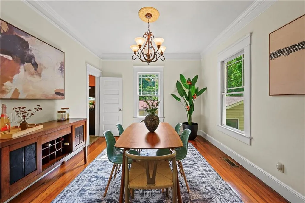 Dining space with crown molding, wood-type flooring, and a chandelier
