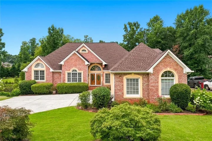 Traditional brick facade residence with a brown shingle roof