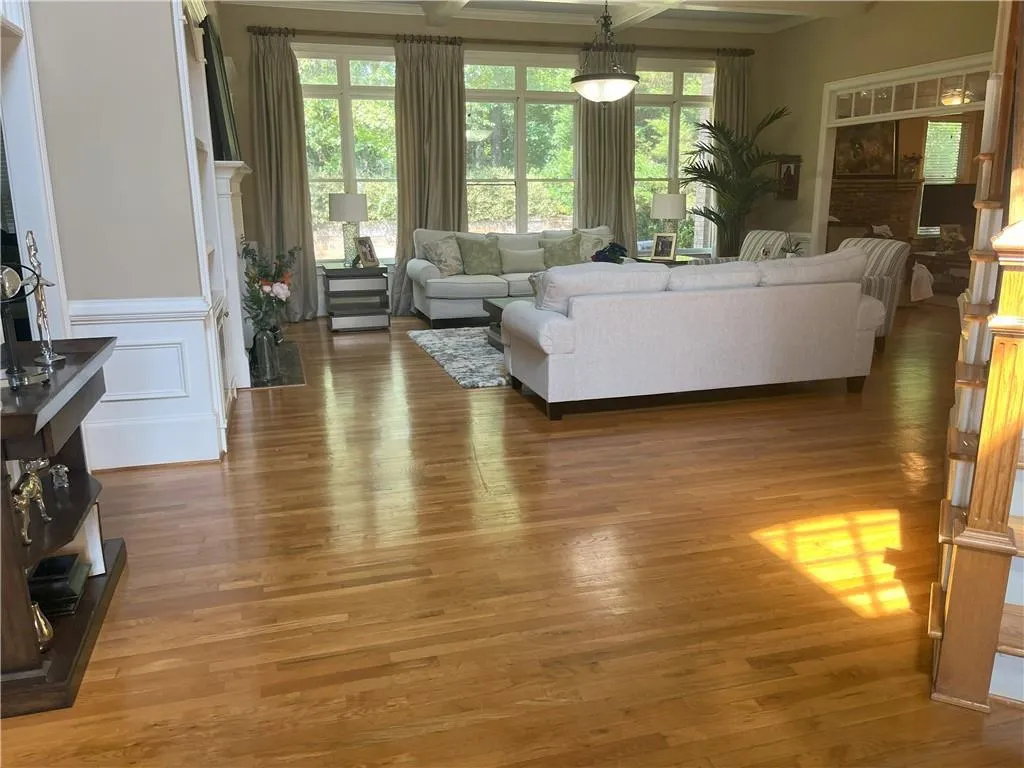 Living room featuring light wood finished floors, beam ceiling, and coffered ceiling