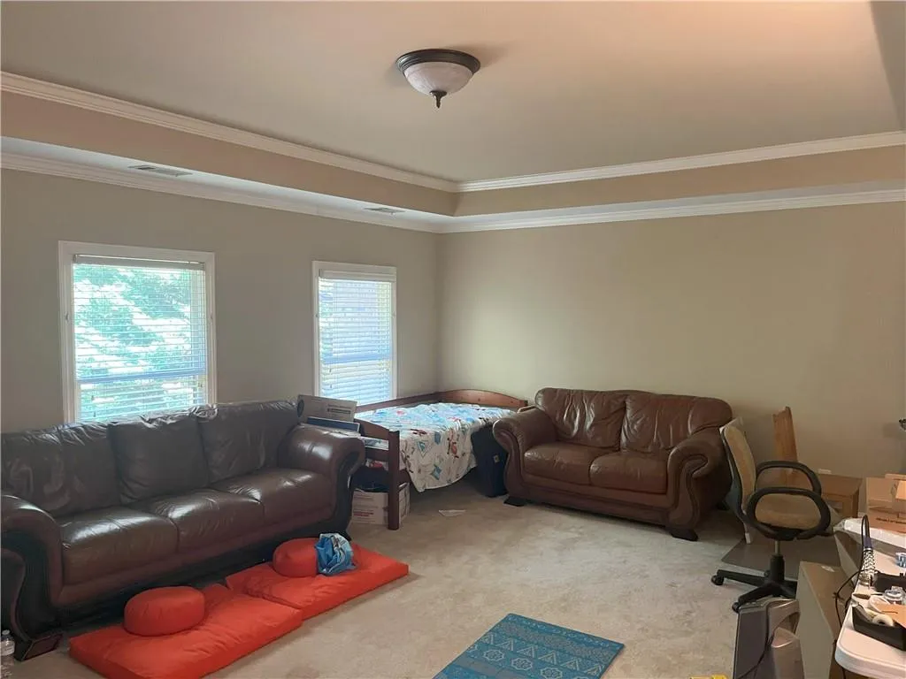Carpeted living room with crown molding