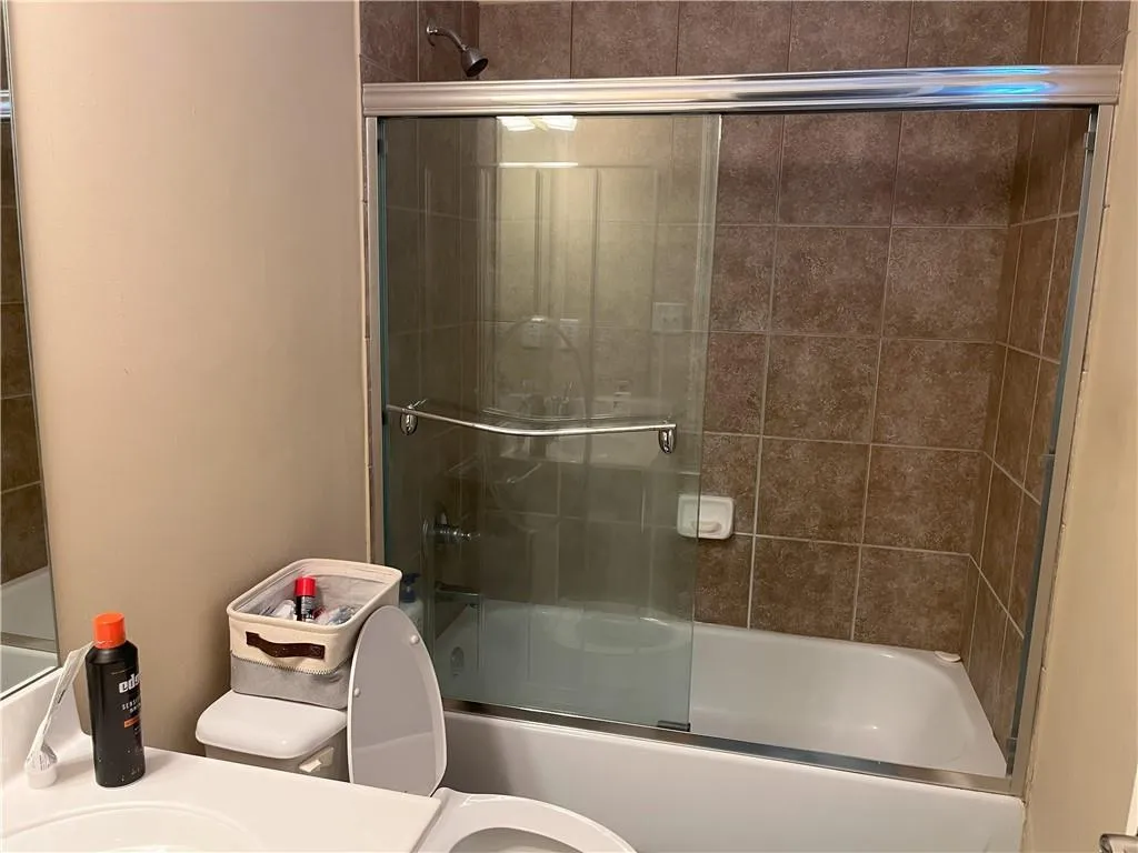 Bathroom featuring combined bath / shower with glass door and vanity