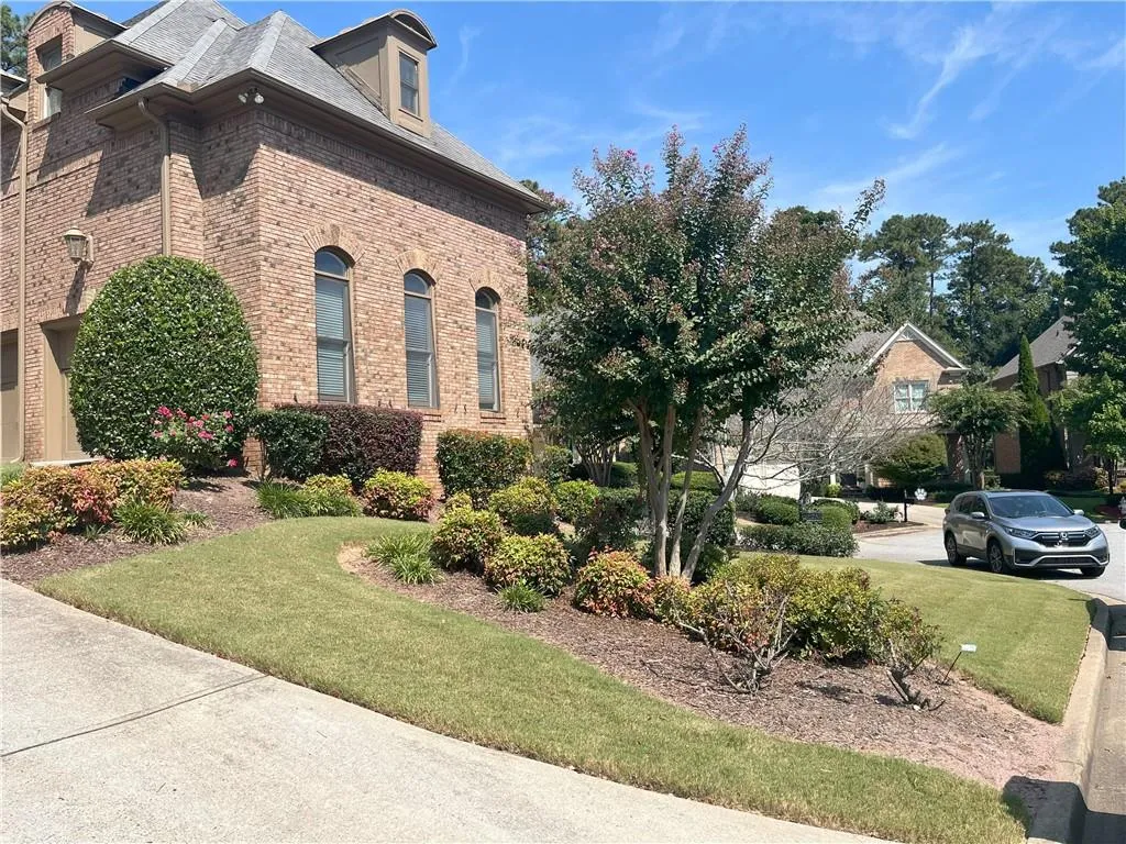 View of home's exterior featuring brick siding and a lawn
