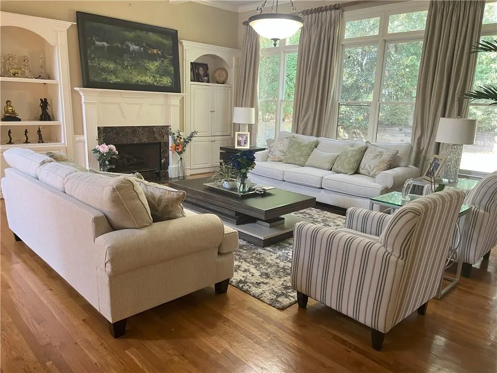 Living area featuring a high end fireplace, wood finished floors, and crown molding
