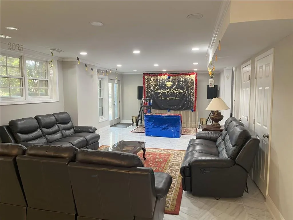 Living area with crown molding and recessed lighting